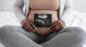 black pregnant woman holding ultrasound image
